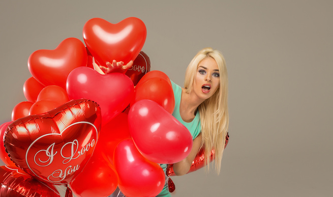 Blond surprised woman with red balloons heart