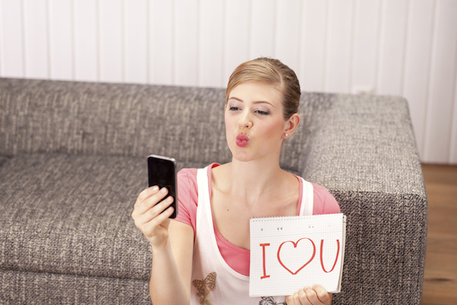 Junge Frau macht Selfi, Notizblock, I love you, Kussmund