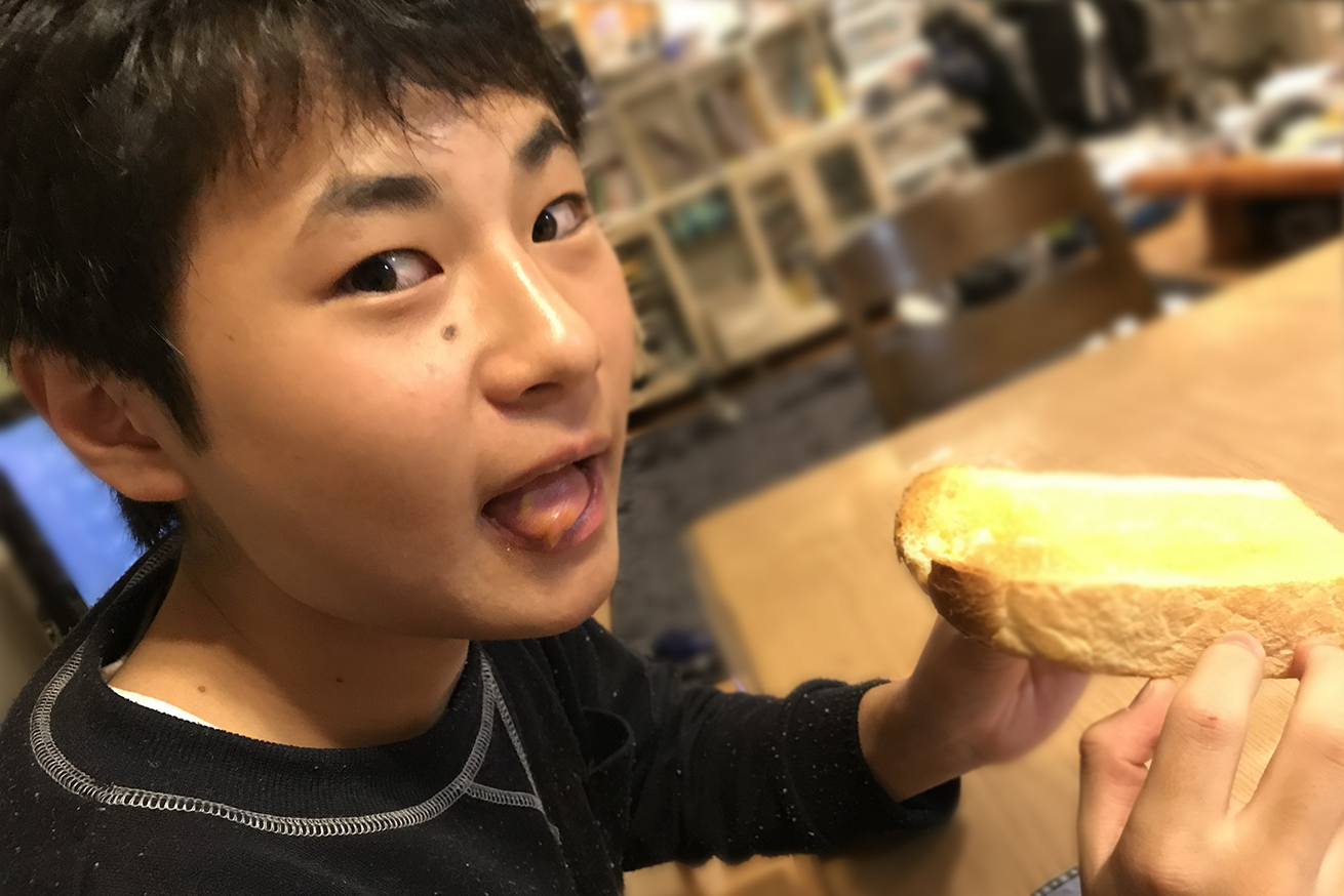 美味しそうにパンを食べる息子