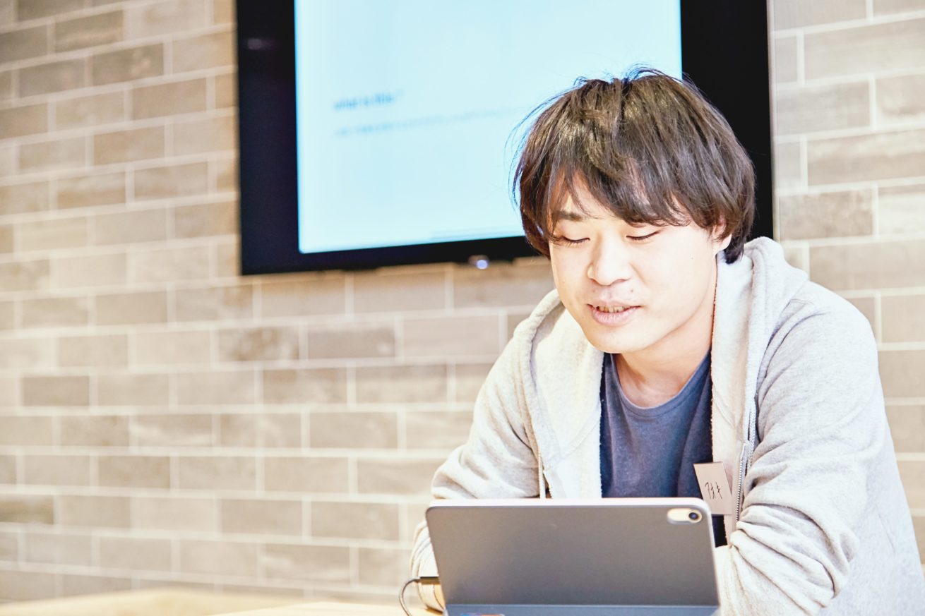 iPadの画面を見ながら話す青木さん
