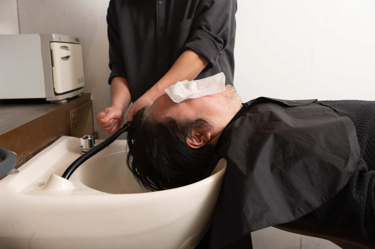 髪の毛を洗っている男性