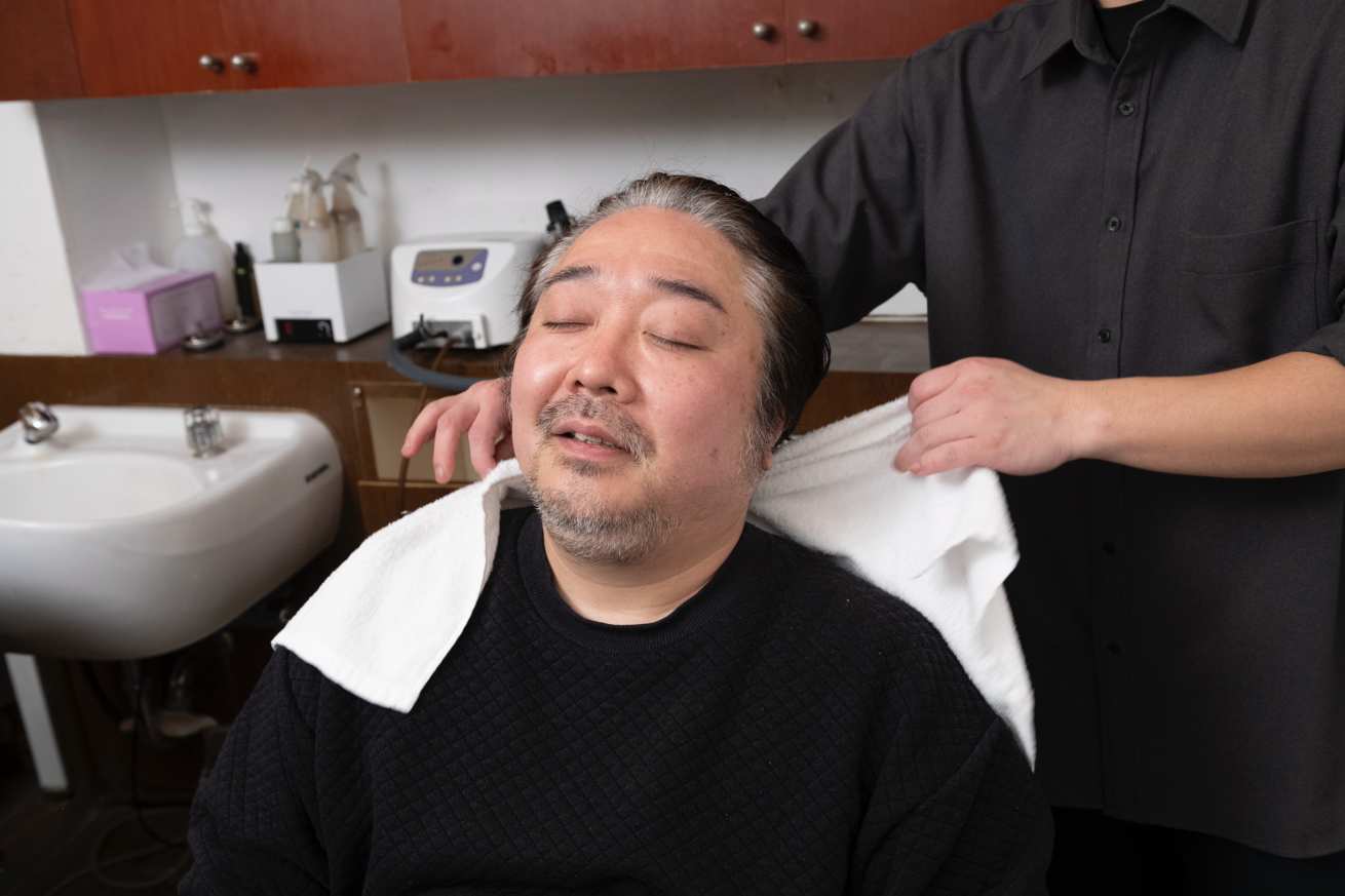 髪の毛を拭いている男性